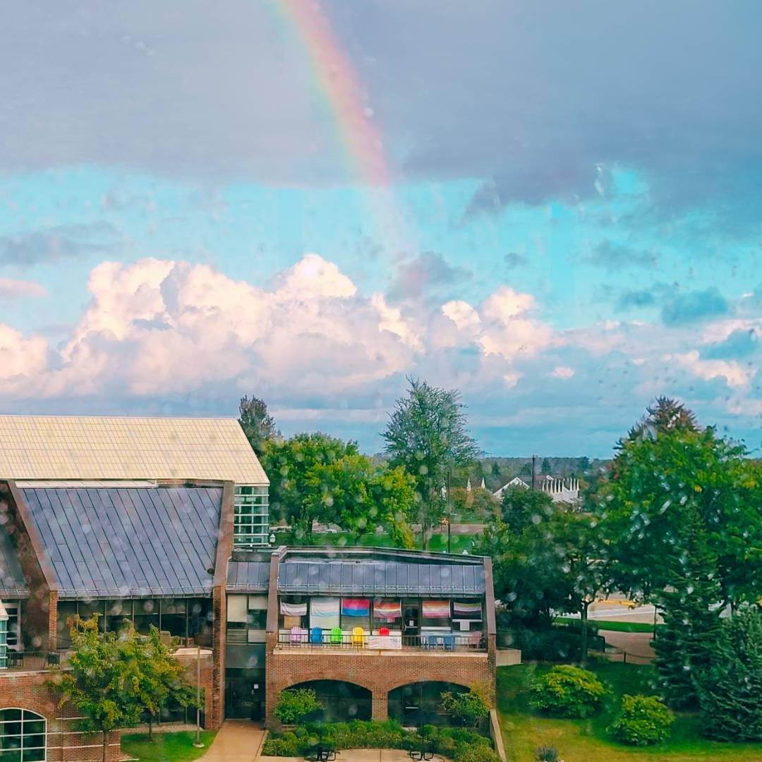 The LGBT Resource patio from across the Zumberge pond with a rainbow in the background